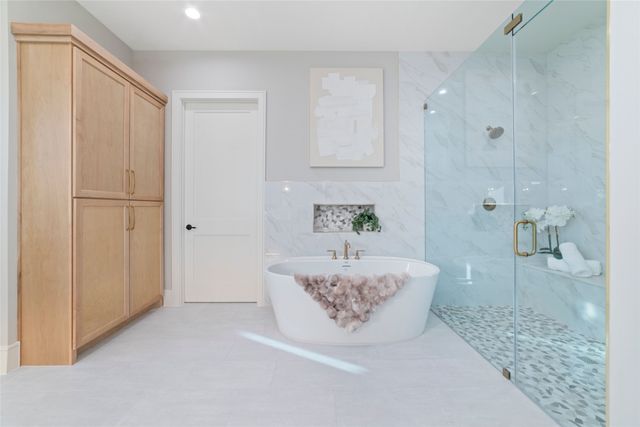 a spacious bathroom with a tub shower and mirror