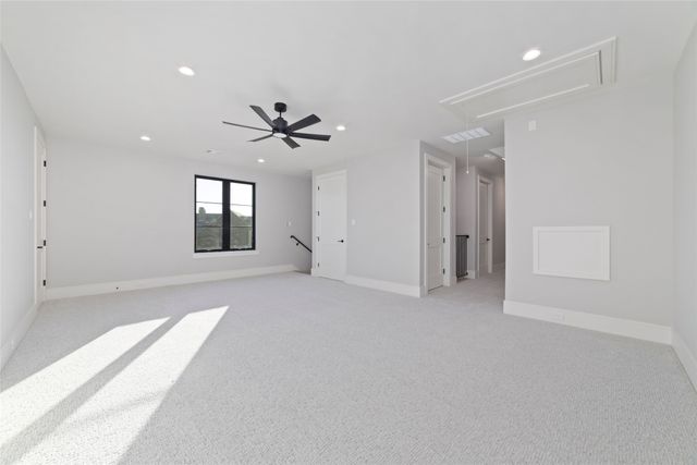 an empty room with chandelier fan and windows