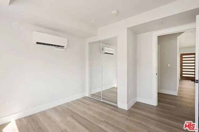 an empty room with wooden floor & windows