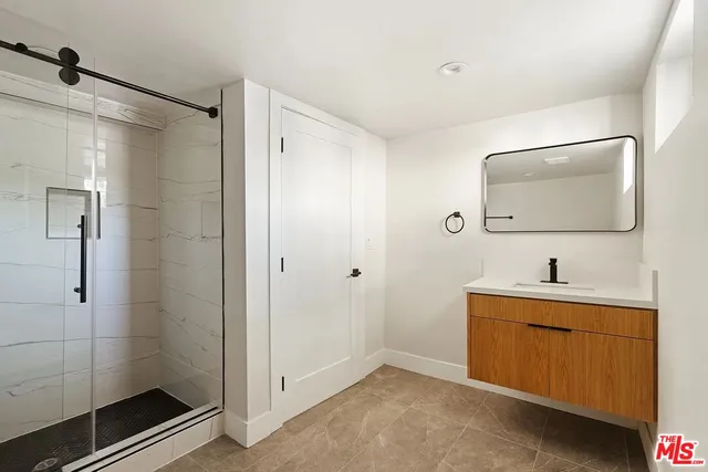 a bathroom with a shower sink and mirror