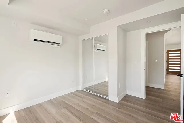 an empty room with wooden floor & windows