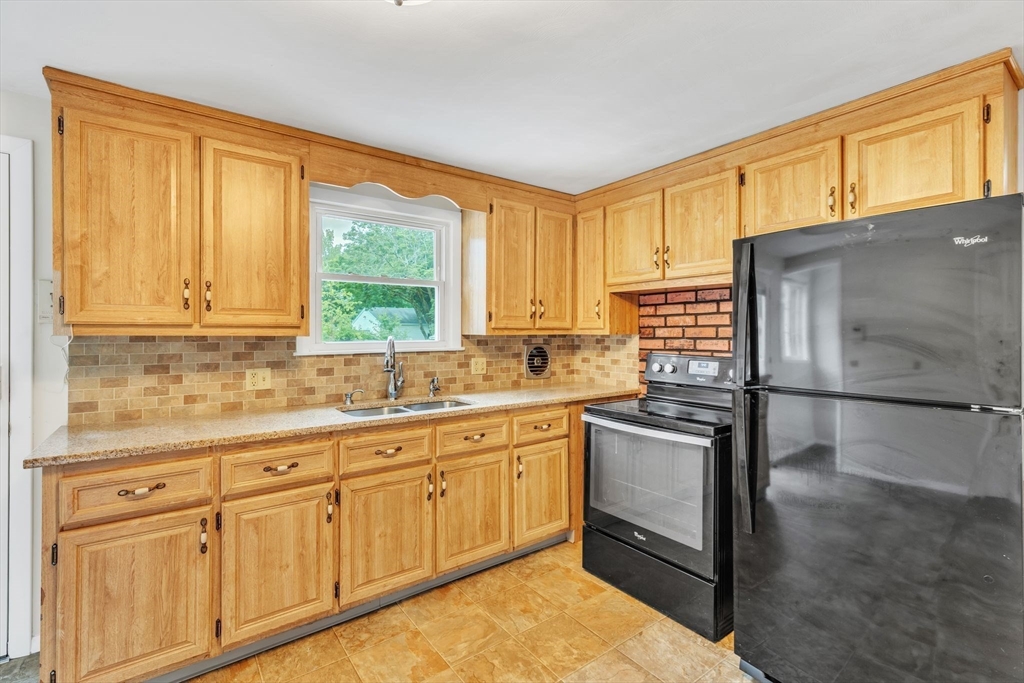 139 Prouty Street Springfield, MA 01119 - Photo 3 of 14 a kitchen with stainless steel appliances granite countertop a stove a sink and a microwave