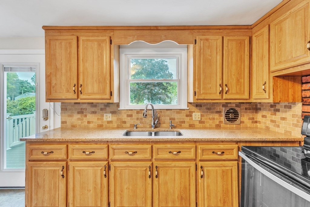 139 Prouty Street Springfield, MA 01119 - Photo 4 of 14 a kitchen with stainless steel appliances white cabinets and a window