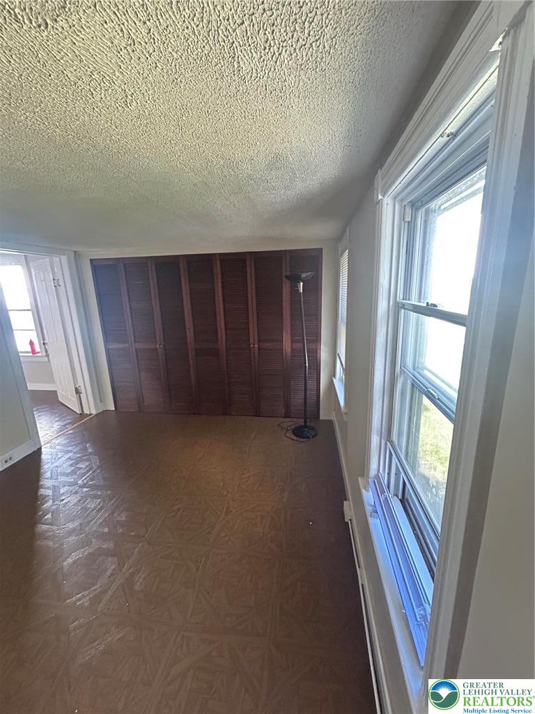 1122 East 4th Street Bethlehem, PA 18015 - Photo 9 of 13 Natural light floods this versatile room through dual skylights, illuminating the textured walls and wood-paneled ceiling.