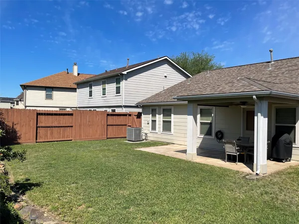 a view of a house with a patio and a yard