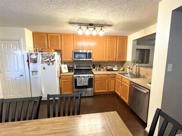 a kitchen with a sink appliances cabinets and a large window