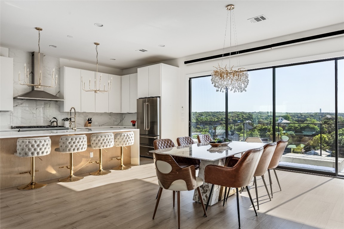 3138 Chisholm Trail Austin, TX 78734 - Photo 11 of 40 a dining room with stainless steel appliances granite countertop a stove a refrigerator a oven a sink with a dining table and chairs with wooden floor