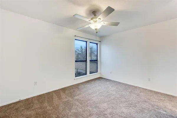 an empty room with chandelier fan