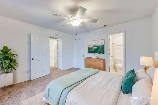 a bedroom with a large bed and a chandelier