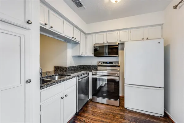 a kitchen with stainless steel appliances a refrigerator stove and microwave