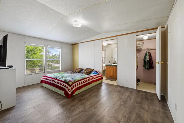 a room with wooden floor pool table and a window