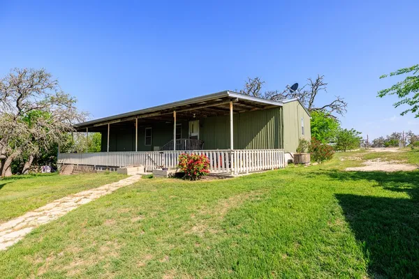 a view of a house with yard and deck