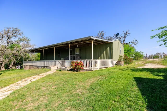 a view of a house with yard and deck