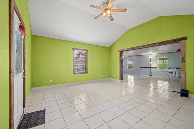 a view of a room with window a ceiling fan and refrigerator