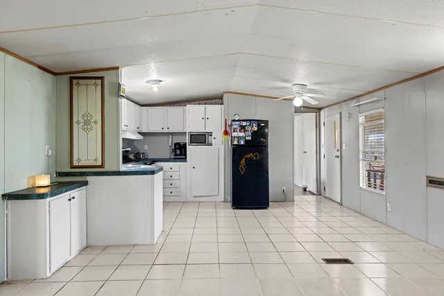 a kitchen with granite countertop a refrigerator and a stove top oven