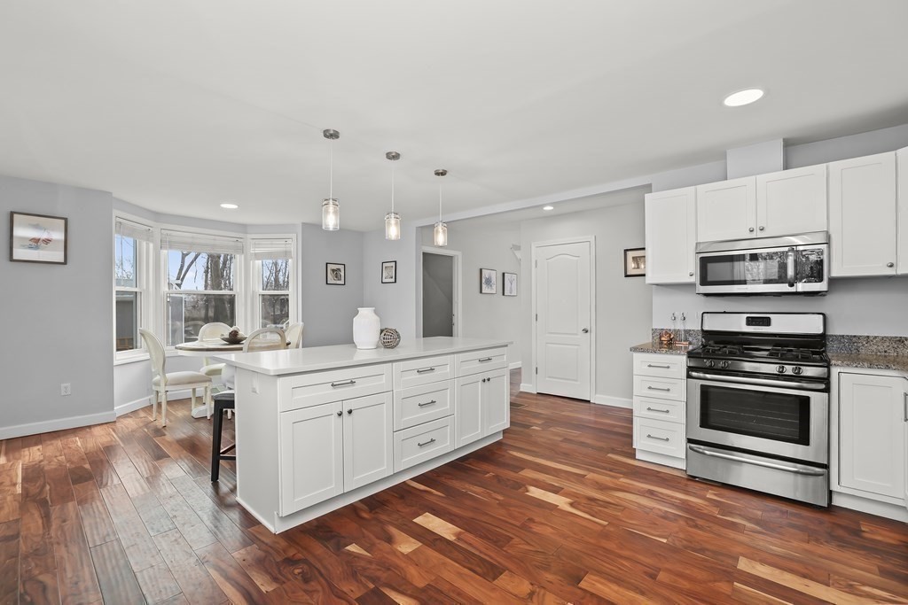 4 Rowe Court, Unit 4 Boston, MA 02131 - Photo 13 of 41 a large kitchen with stainless steel appliances granite countertop a stove a sink dishwasher and a oven with white cabinets