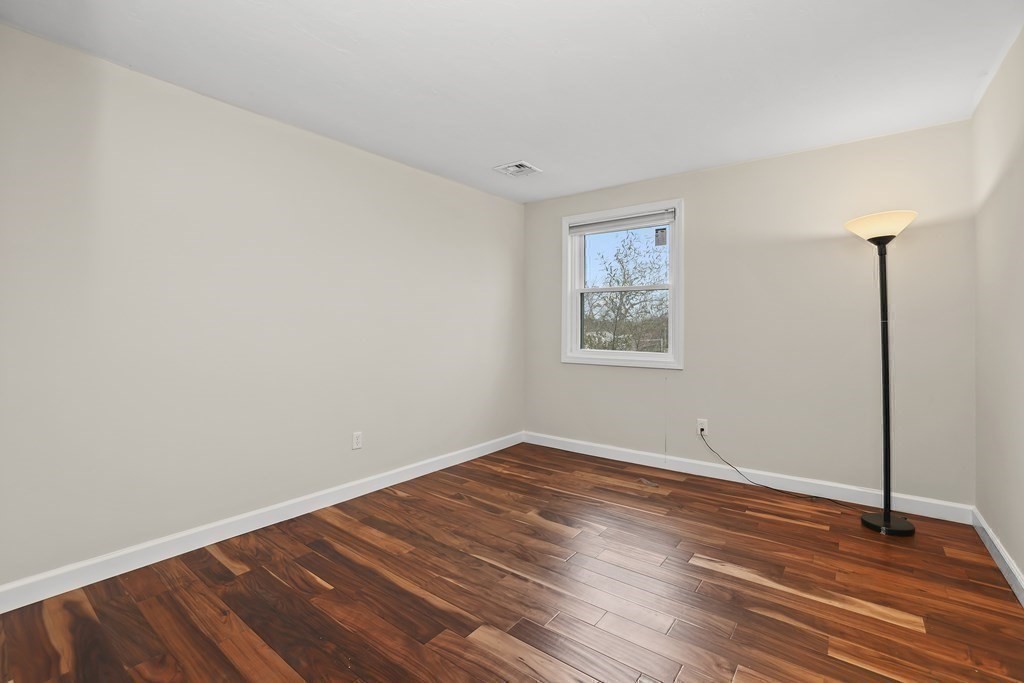 4 Rowe Court, Unit 4 Boston, MA 02131 - Photo 22 of 41 an empty room with wooden floor and windows