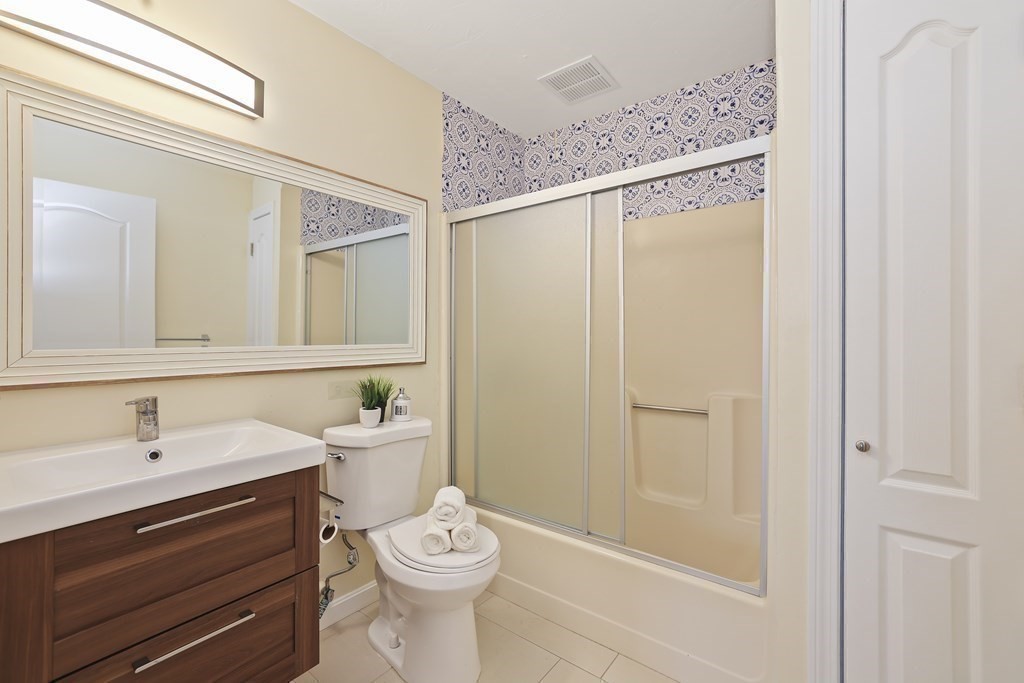 4 Rowe Court, Unit 4 Boston, MA 02131 - Photo 23 of 41 a bathroom with a sink mirror vanity and toilet