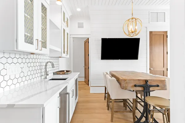 a dining room with wooden floor a chandelier a wooden table and chairs