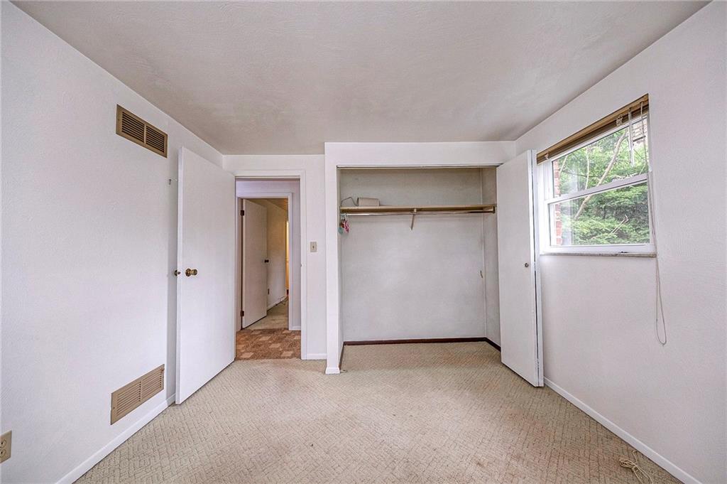 1023 Middle Road Glenshaw, PA 15116 - Photo 29 of 44 A functional look at the second bedroom, showcasing a wide, built-in closet with double doors, hanging rods, and an overhead storage shelf.