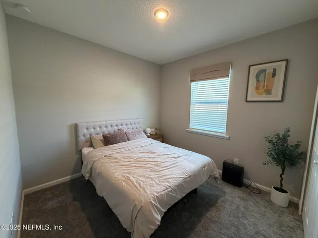 a bedroom with a bed and a potted plant