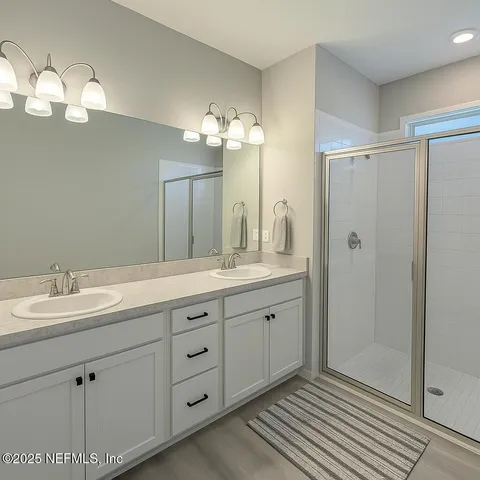 a bathroom with a double vanity sink and a mirror