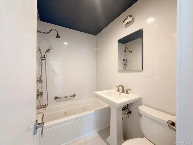 a bathroom with a sink mirror toilet and bathtub