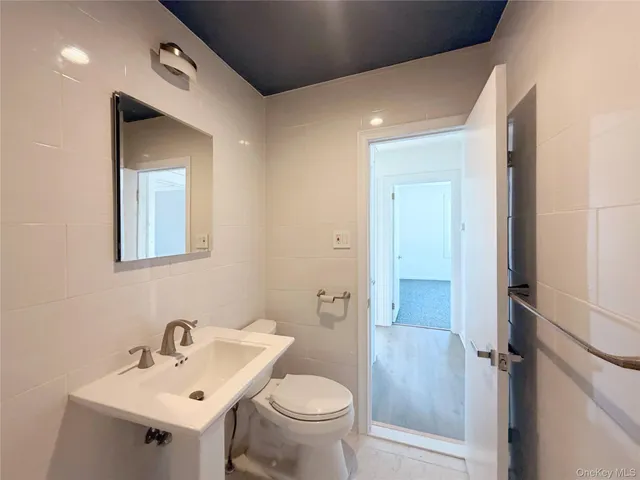 a bathroom with a toilet sink and mirror