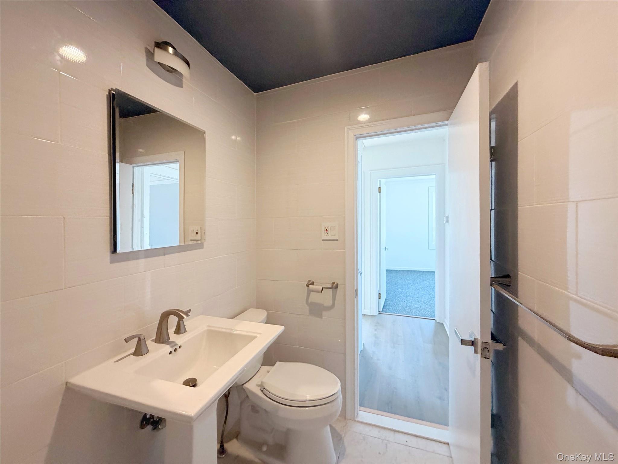 20 Bogota Road Mastic Beach, NY 11951 - Photo 15 of 34 a bathroom with a toilet sink and mirror
