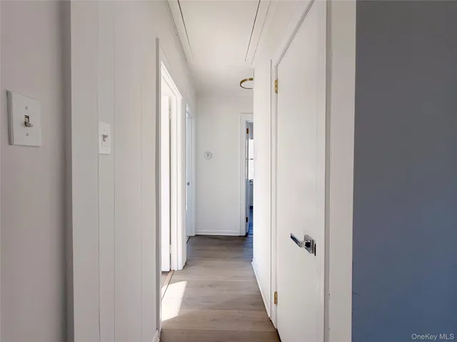 a view of a hallway with wooden floor and closet