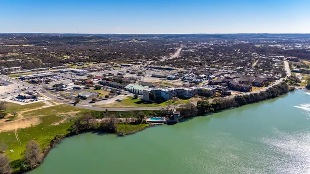 an aerial view of residential houses with outdoor space and lake view