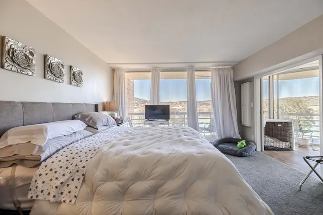 a bedroom with a bed and a large mirror on the dresser