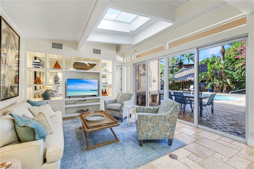 210 Central Avenue Naples, FL 34102 - Photo 14 of 50 a living room with furniture a flat screen tv and a floor to ceiling window