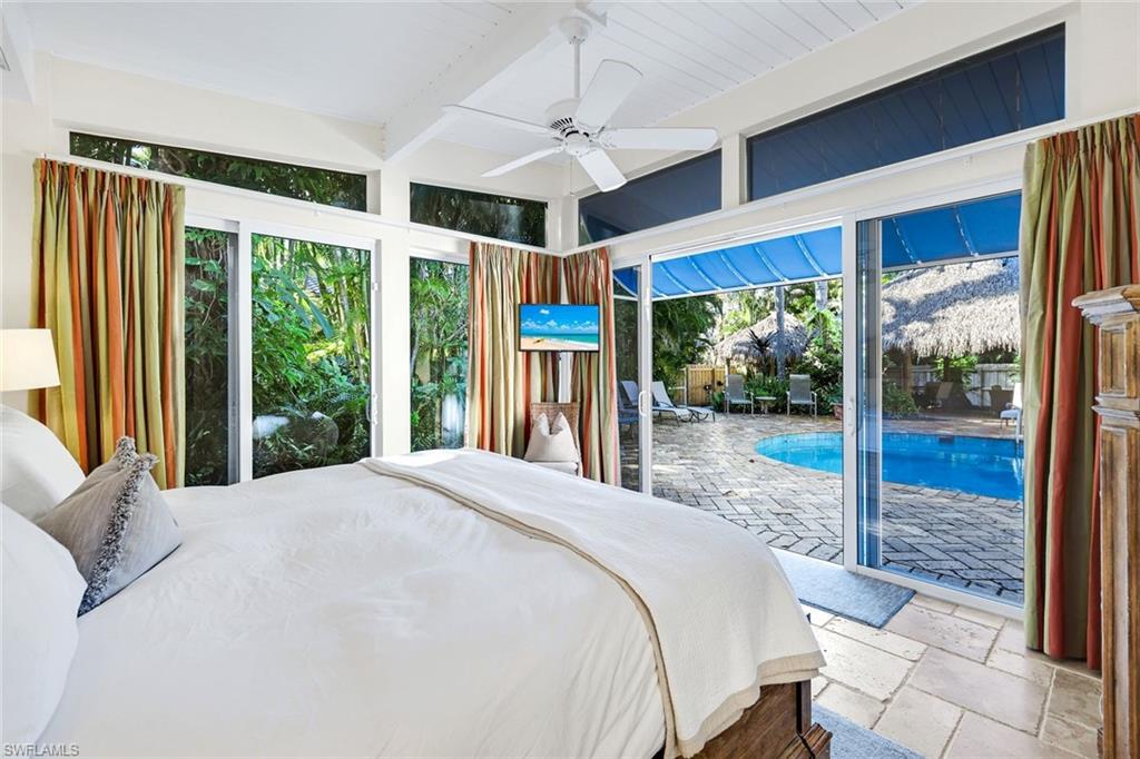 210 Central Avenue Naples, FL 34102 - Photo 16 of 50 a bed sitting in a bedroom next to a large window