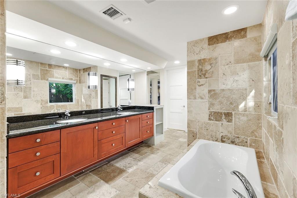 210 Central Avenue Naples, FL 34102 - Photo 19 of 50 a large spacious bathroom with a tub sink shower and mirror