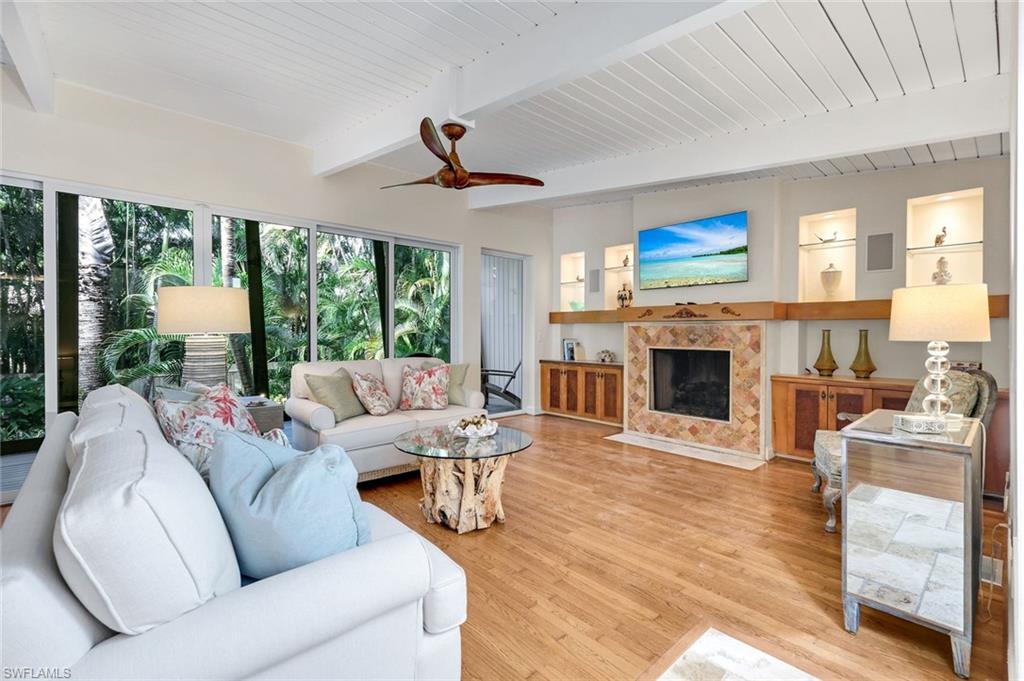 210 Central Avenue Naples, FL 34102 - Photo 20 of 50 a living room with furniture a fireplace and a flat screen tv