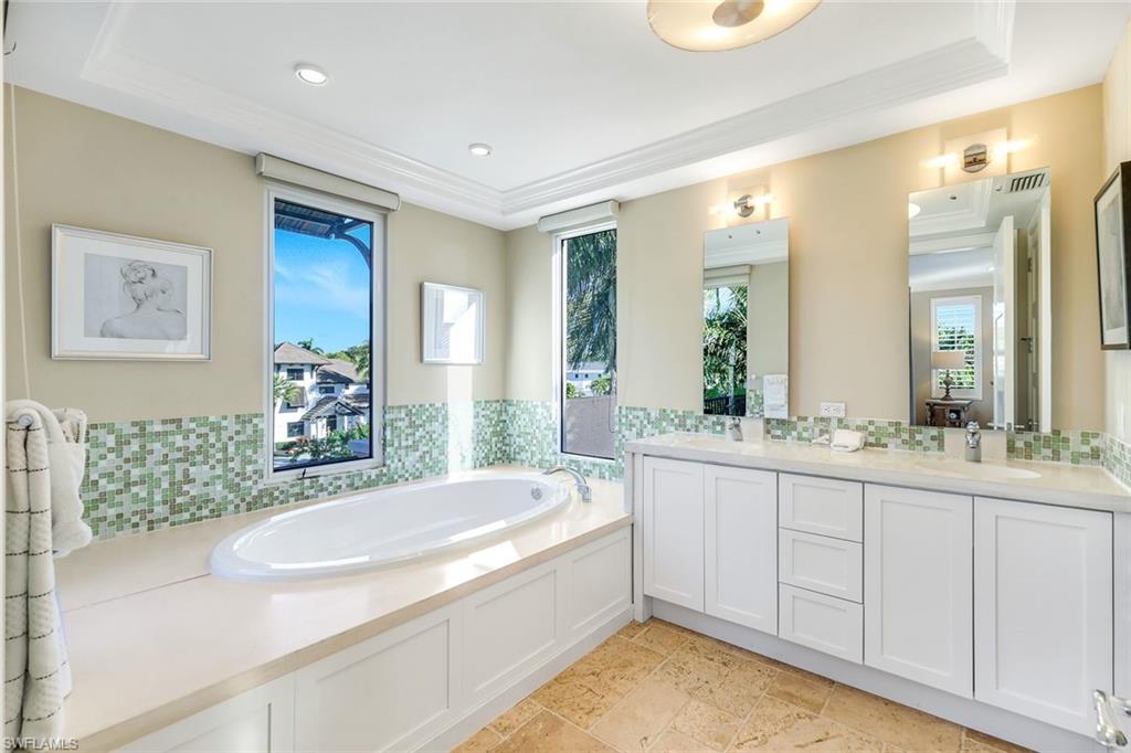 210 Central Avenue Naples, FL 34102 - Photo 35 of 50 a spacious bathroom with a granite countertop tub sink and mirror