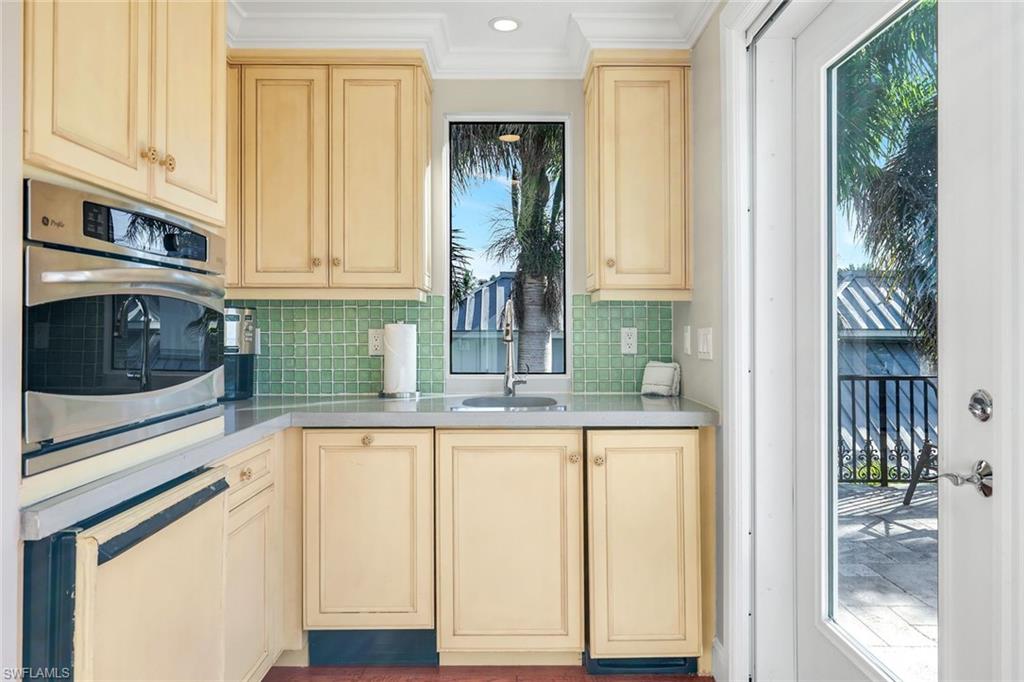 210 Central Avenue Naples, FL 34102 - Photo 36 of 50 a kitchen with granite countertop white cabinets and stainless steel appliances