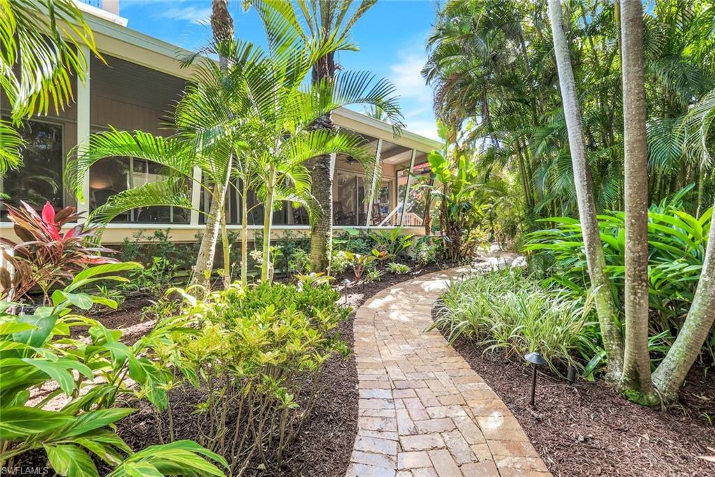 210 Central Avenue Naples, FL 34102 - Photo 41 of 50 a flower plants in front of yellow house