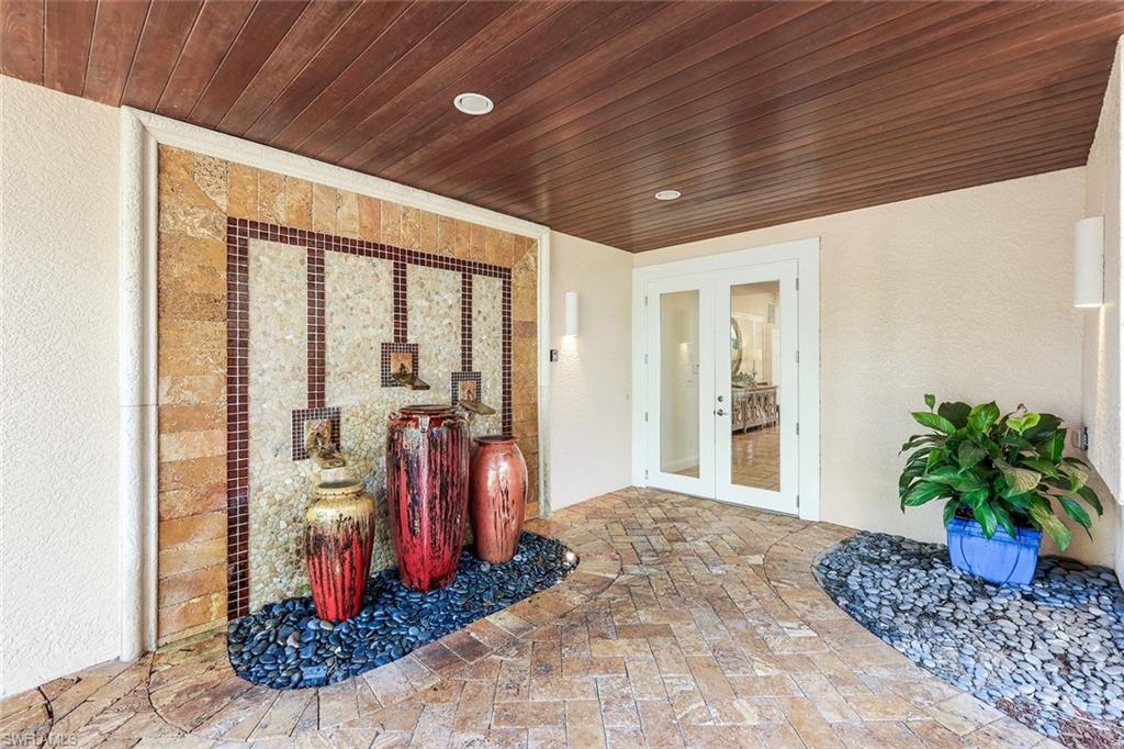 210 Central Avenue Naples, FL 34102 - Photo 6 of 50 a room with lots of potted plants and glass door