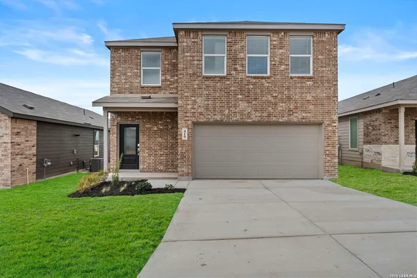 a front view of a house with a yard and garage