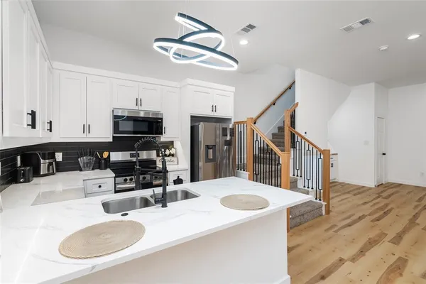a large white kitchen with wooden floors and a fireplace