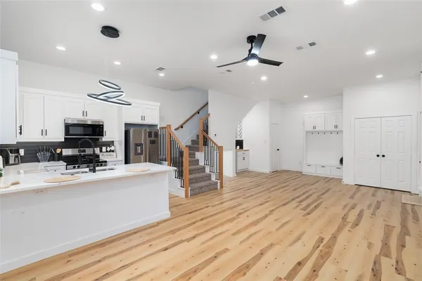 a kitchen with a sink appliances and a chandelier