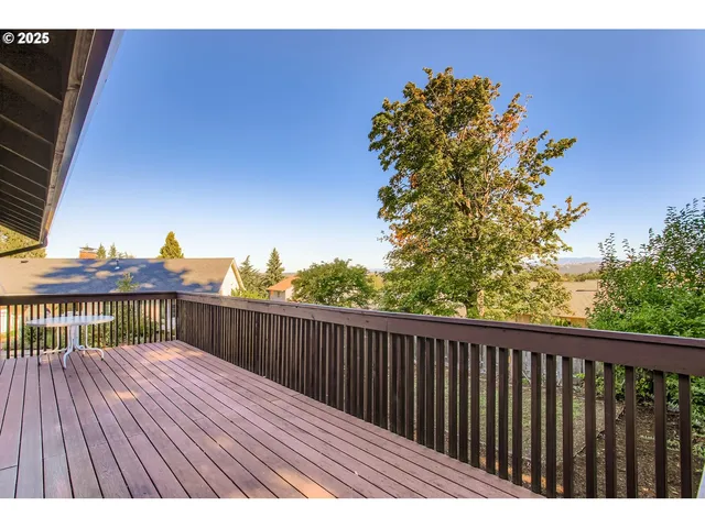 a view of a balcony with wooden floor and fence