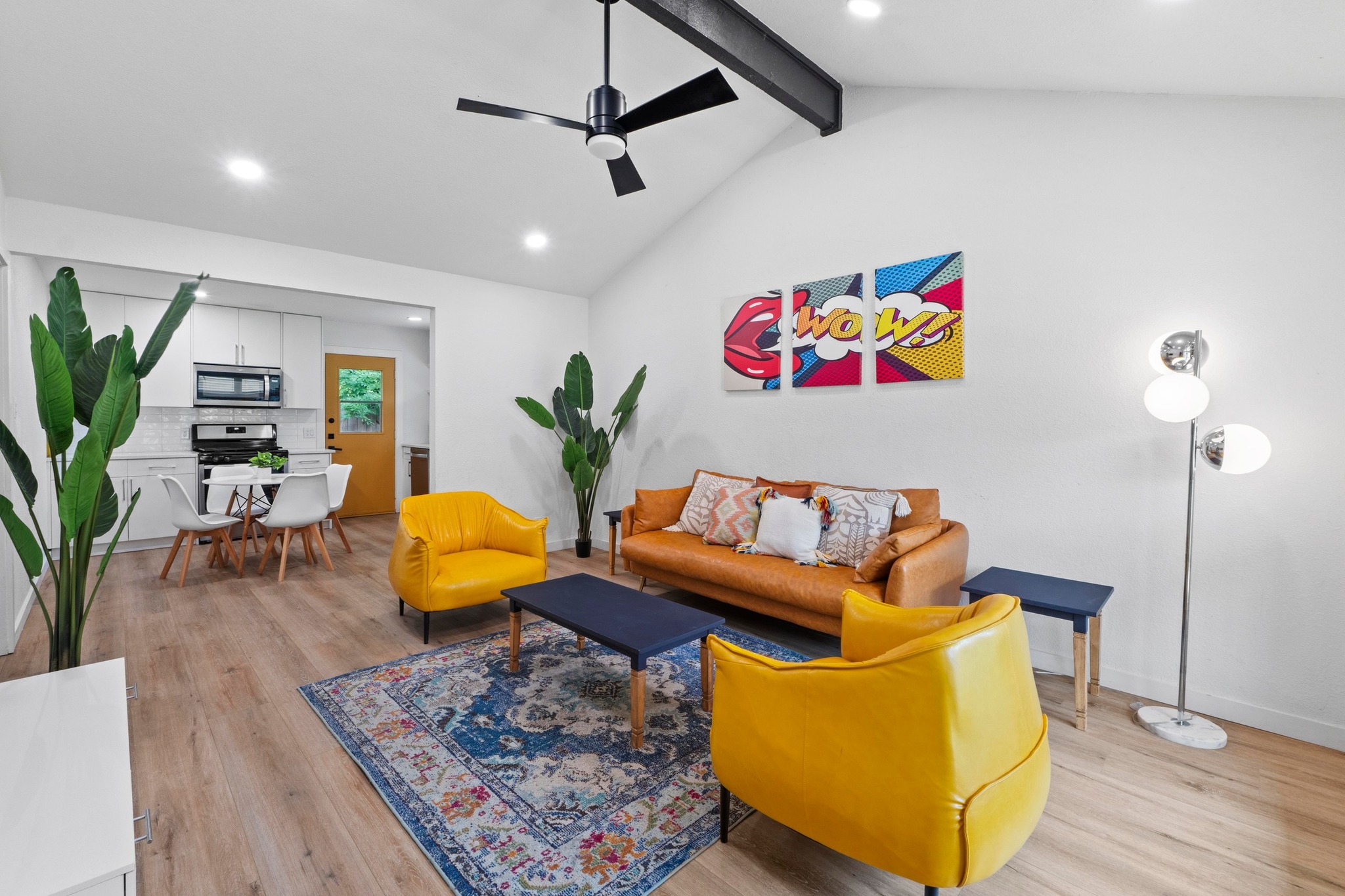 10601 Macmora Road, Unit B Austin, TX 78758 - Photo 3 of 22 A vibrant living area with high ceilings and rich wood flooring, featuring an open-concept kitchen beyond.