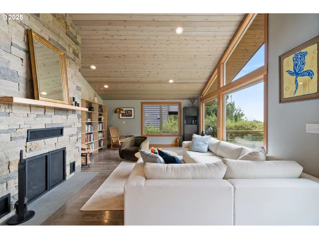 a living room with fireplace furniture and a large window