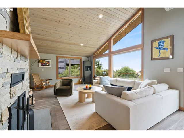 a living room with fireplace furniture and a large window