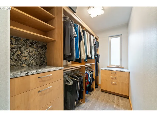 a view of walk in closet with clothes and shoes