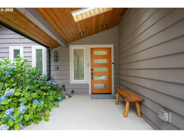 a backyard of a house with a bench and potted plant