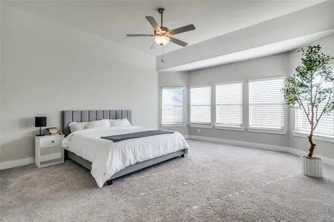 a spacious bedroom with a bed and a large window